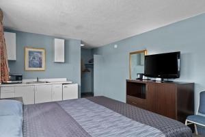 韦纳奇Holiday Lodge的一间卧室配有一张床和一台平面电视
