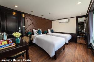 下龙湾Amanda Legend Cruise Ha Long Bay的酒店客房配有两张床和一张书桌