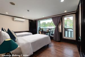 下龙湾Amanda Legend Cruise Ha Long Bay的酒店客房设有两张床和一个阳台。