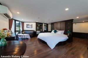 下龙湾Amanda Legend Cruise Ha Long Bay的酒店客房设有一张大床和一张桌子。