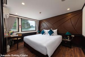下龙湾Amanda Legend Cruise Ha Long Bay的一间卧室配有一张大床和一张书桌