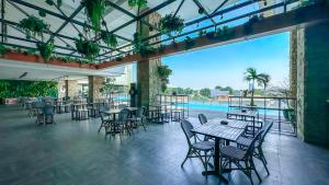 加拉旺卡拉旺瑞士贝尔国际酒店的一间带桌椅的餐厅和一个游泳池