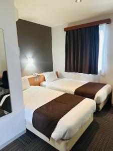 田边市哈那亚酒店的酒店客房设有两张床和窗户。