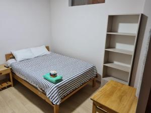 奥克萨潘帕LIRI House的一间小卧室,配有床和书架