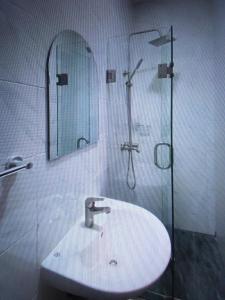 莱基Light house hotel and apartments Lekki phase 1的浴室配有盥洗盆和带镜子的淋浴