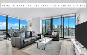 墨尔本Melbourne Lifestyle Apartments – Best Views on Collins的客厅配有沙发和桌子