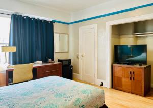旧金山海军上将酒店的一间卧室配有一张床、一张书桌和一台电视