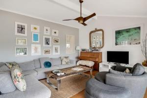 特里格尔Stylish Beach Home - Moments from Water的客厅配有沙发、两把椅子和电视