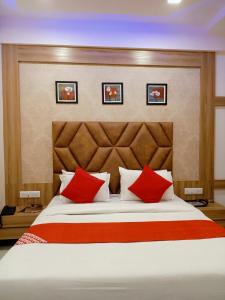 艾哈迈达巴德HOTEL LORDS IN的一间卧室配有一张带红色枕头的大床