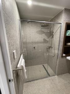 HardenHarden Country Club Motel的浴室里设有玻璃门淋浴