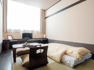 泉佐野瑞库高级酒店的一间卧室配有一张床和一张桌子