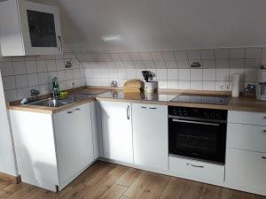伦茨堡Ferienwohnung Arff的厨房配有白色橱柜和水槽