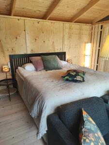 雷克桑德Sjugare Gård Glamping的一间卧室配有带枕头的床铺和沙发