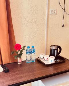 库塔伊西Green Flower Hotel的配有瓶装水和杯子的桌子以及咖啡设施