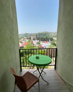 库塔伊西Green Flower Hotel的阳台上配有绿色的桌椅