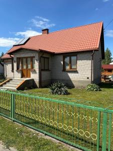 Stare DolistowoKrok od Biebrzy的一座红色屋顶和绿色围栏的房子