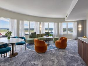 墨尔本墨尔本机场宾乐雅酒店的客厅设有桌椅和窗户。