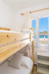 Es GrauFantástico apartamento frente al mar en Menorca的卧室设有两张双层床,享有海滩美景