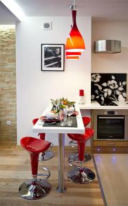 扎科帕内Apartament Cicha Woda Zakopane的厨房配有红色的吧台凳和白色的桌子