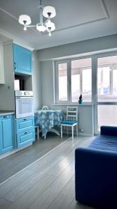 阿拉木图Новая квартира с панорамным видом на горы的一间带蓝色橱柜的客厅和一间厨房
