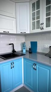 阿拉木图Новая квартира с панорамным видом на горы的厨房配有蓝色橱柜和水槽