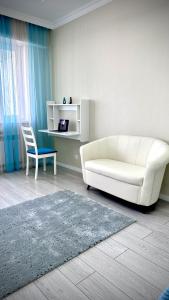 阿拉木图Новая квартира с панорамным видом на горы的客厅配有白色沙发和蓝色椅子