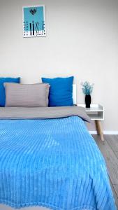 阿拉木图Новая квартира с панорамным видом на горы的一张带蓝色毯子和蓝色枕头的床