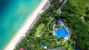 三亚三亚银泰阳光度假酒店（享沙滩区，椰林泳池）的享有海滩和蓝色湖泊的上方景色