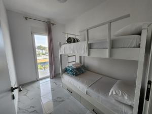 圣金Anchor Apartments的白色卧室设有双层床和窗户