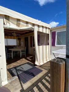 拉波勒Mobil Home 5 personnes - Camping *** Les Ollivaud-的一个带遮阳篷和桌子的庭院