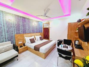 新德里Hotel MARISA GRAND Near Delhi Airport BY Aero Home的酒店的客房 - 带一张床、椅子和电视
