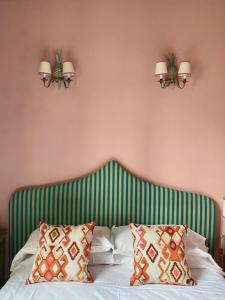 佛罗伦萨赫米缇吉酒店的一间卧室配有一张绿色和白色条纹的床