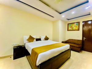 新德里Hotel Imperial Inn - Nehru Enclave的一间卧室配有一张大床和一张沙发