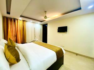 新德里Hotel Imperial Inn - Nehru Enclave的一间卧室配有一张大床和电视