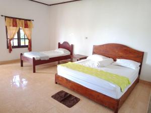 LagudriHarus Damai Inn的一间卧室,配有两张床
