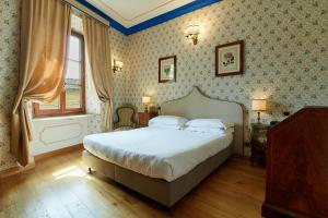 佛罗伦萨赫米缇吉酒店的一间卧室设有一张大床和一个窗户。