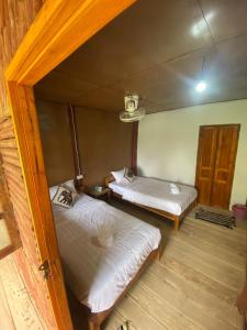 NongkhiawMeexai bungalow guesthouse的小屋内带两张床的房间
