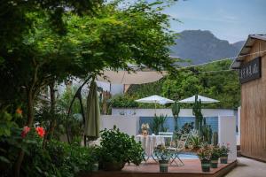 德清莫干山雅泉山居的一个带桌子、遮阳伞和植物的庭院