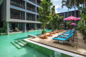 奥南海滩Areetara Aonang Krabi的酒店游泳池设有躺椅和遮阳伞
