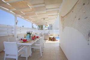 普罗塔拉斯Villa Posidonas 3的白色的用餐室配有桌椅