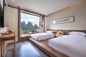 阳朔阳朔格格树饭店的酒店客房设有两张床和窗户。