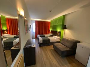 马德里Apartamentos Recoletos的酒店客房,设有两张床和一张沙发