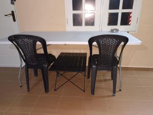 马兰ROOMSTAY NIMAZA Bilik 2的厨房里配有两张黑椅子和一张桌子