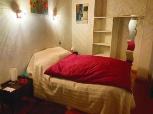 蓬德萨拉尔L'Escapade de JOS gite équestre的一间卧室配有红色的床和镜子