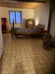 蓬德萨拉尔L'Escapade de JOS gite équestre的卧室配有1张床,铺有瓷砖地板。
