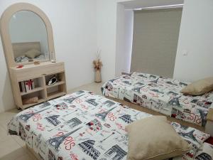 Mār YūsufChaletapartment in Tilal Fanar resort,的一间卧室配有两张床和镜子