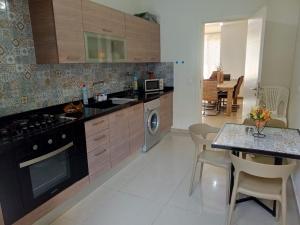 Mār YūsufChaletapartment in Tilal Fanar resort,的厨房配有桌子和炉灶。 顶部烤箱