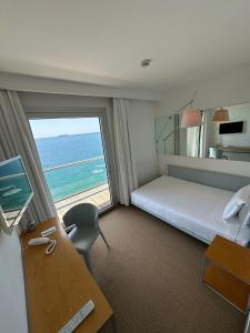 的里雅斯特Hotel Miramare - Adults Only的配有一张床、一张书桌和一扇窗户的酒店客房