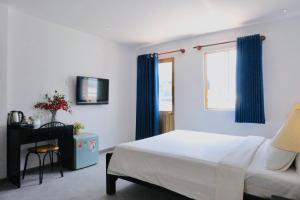 胡志明市Nicecy Hotel - Yersin Street的一间卧室配有床和蓝色窗帘的窗户