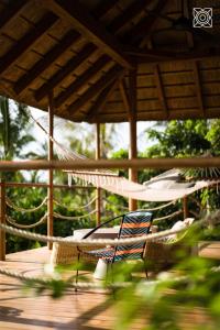 肯杜瓦Zuri Zanzibar的露台设有吊床和甲板上的椅子